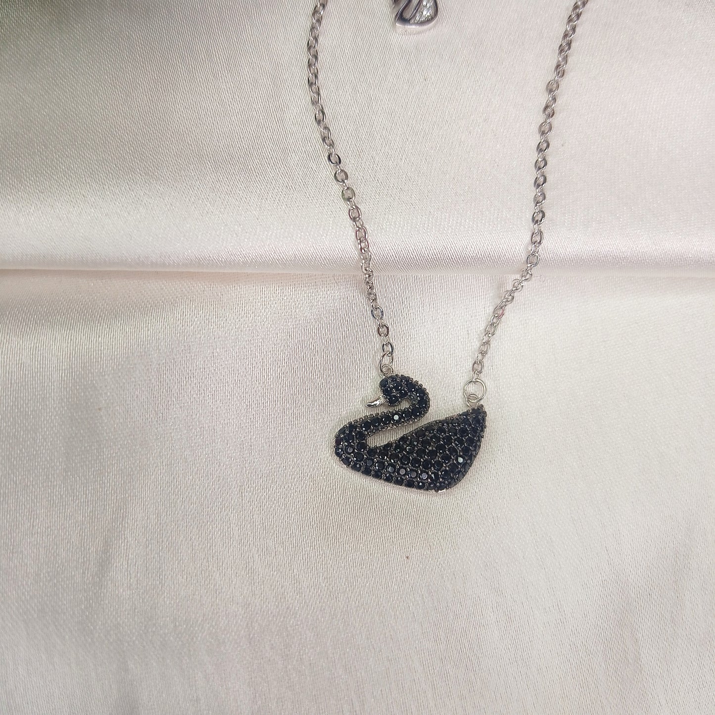 Elegant silver necklace featuring a black swan pendant encrusted with black crystals, adding a touch of sophistication and charm