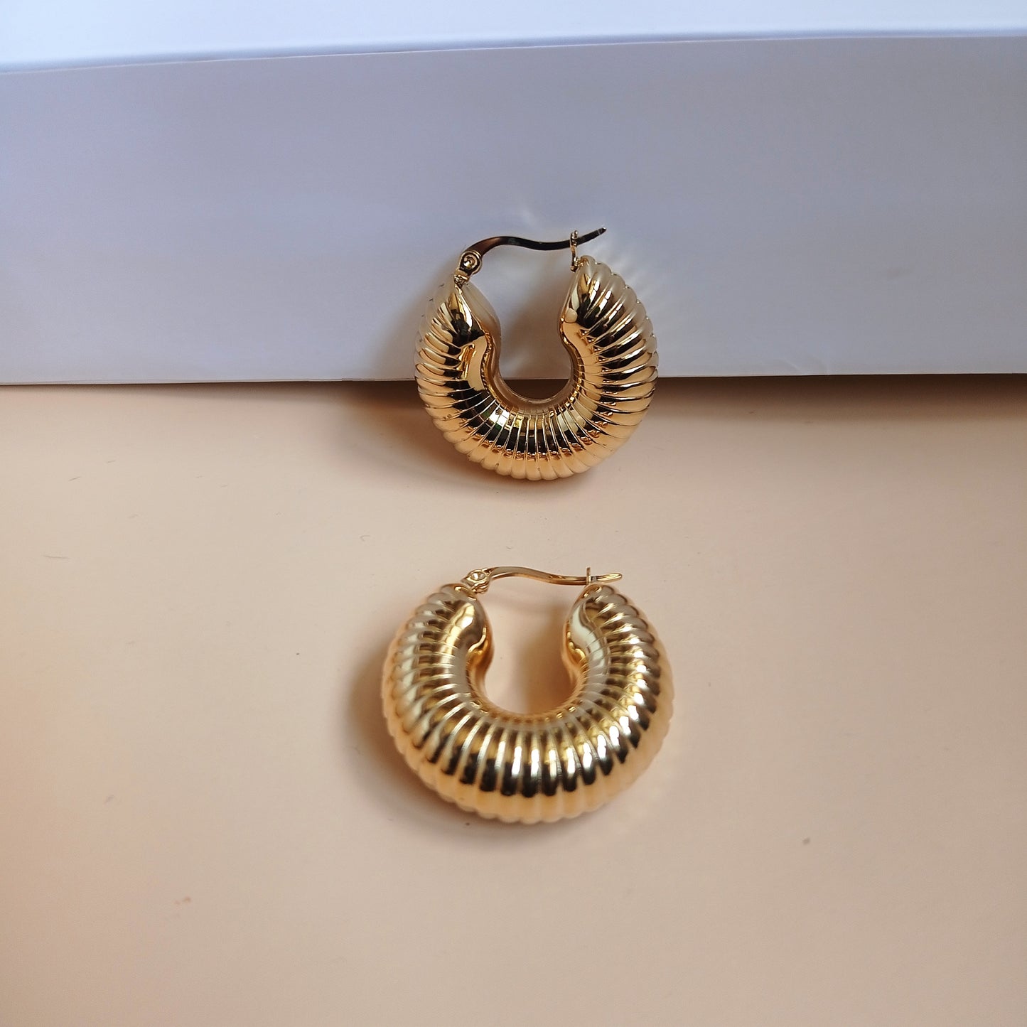 Elegant gold ridged hoop earrings with a vintage charm, styled with a luxe LUSH 24 box and neutral ceramic decor