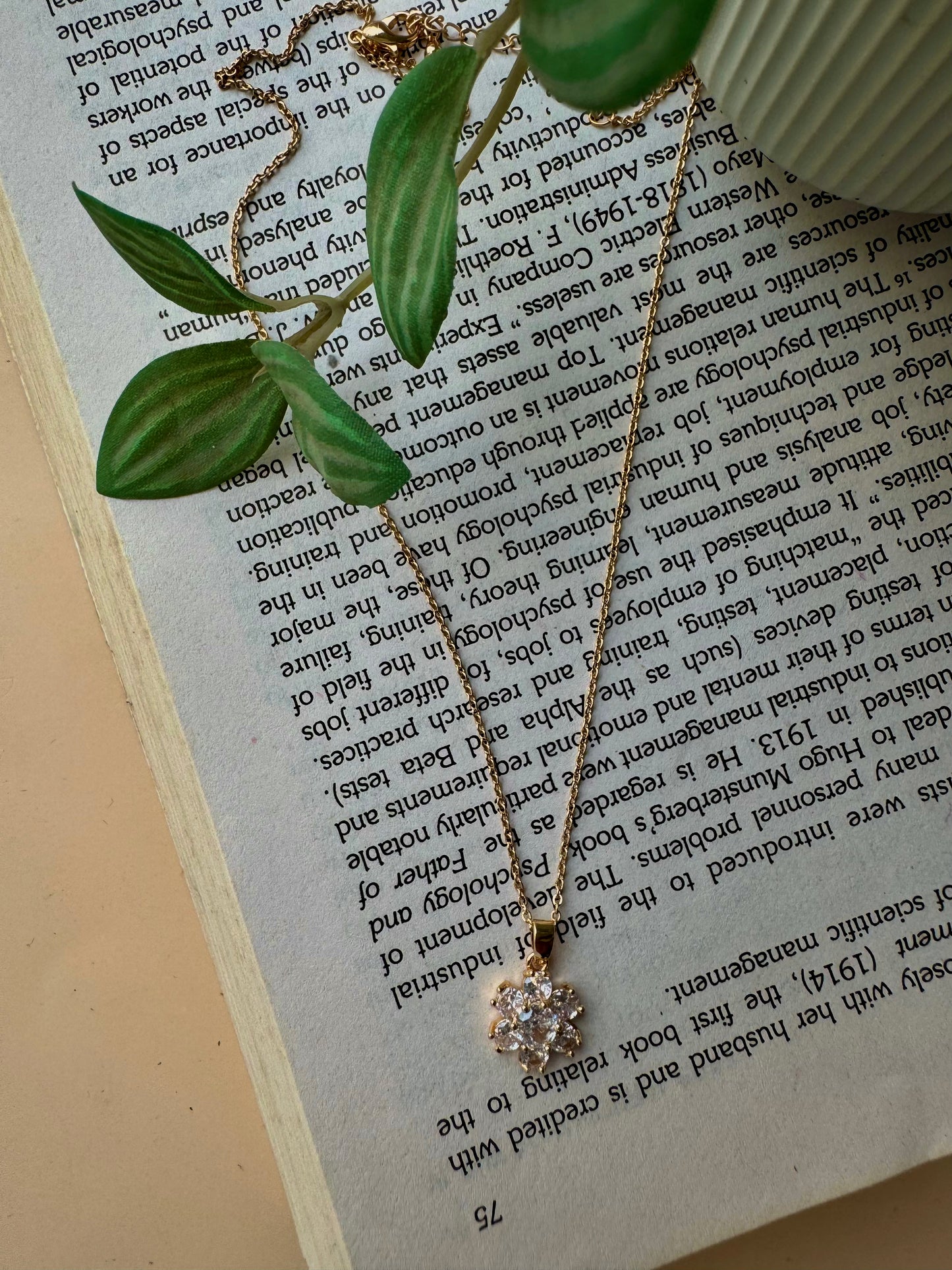 Elegant flower pendant necklace with a modern pendant that resembles a stack of miniature flower, one of which is pavé-set with clear stones. This design is inspired by iconic jewelry styles and could be found in Mumbai.