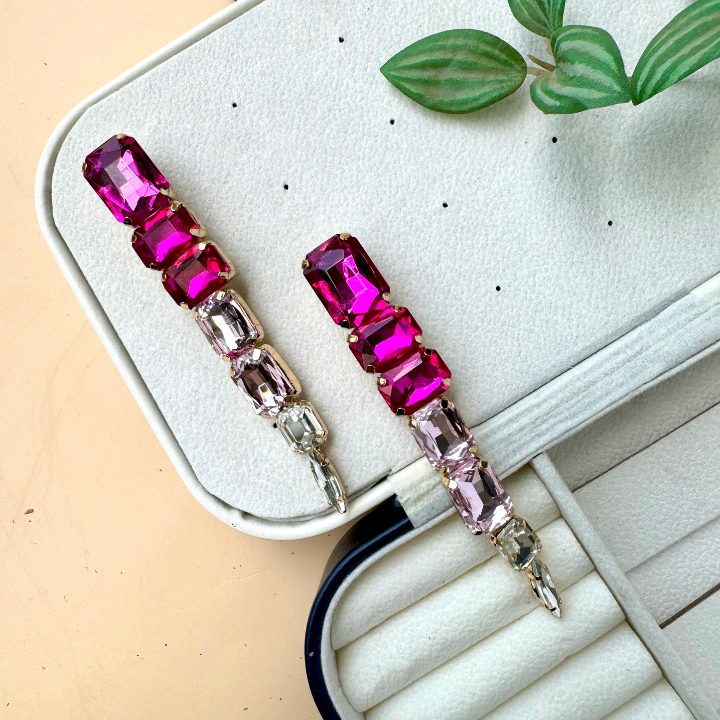 Elegant gradient gemstone drop earrings featuring vibrant pink and blush-toned rectangular crystals, set in gold-tone metal, displayed on a soft jewelry case