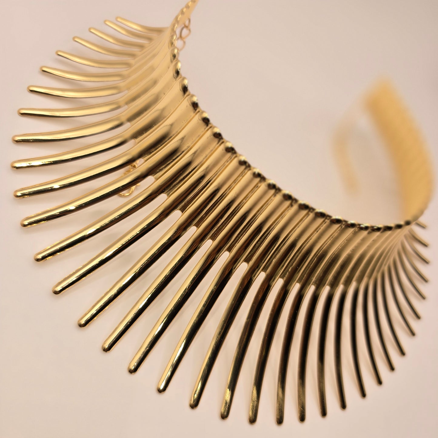 Gold statement necklace on a white display bust with Lush 24 packaging