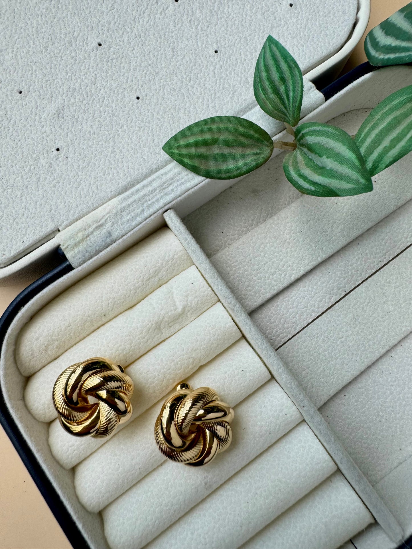 Tarnish-free gold studs on a pillow