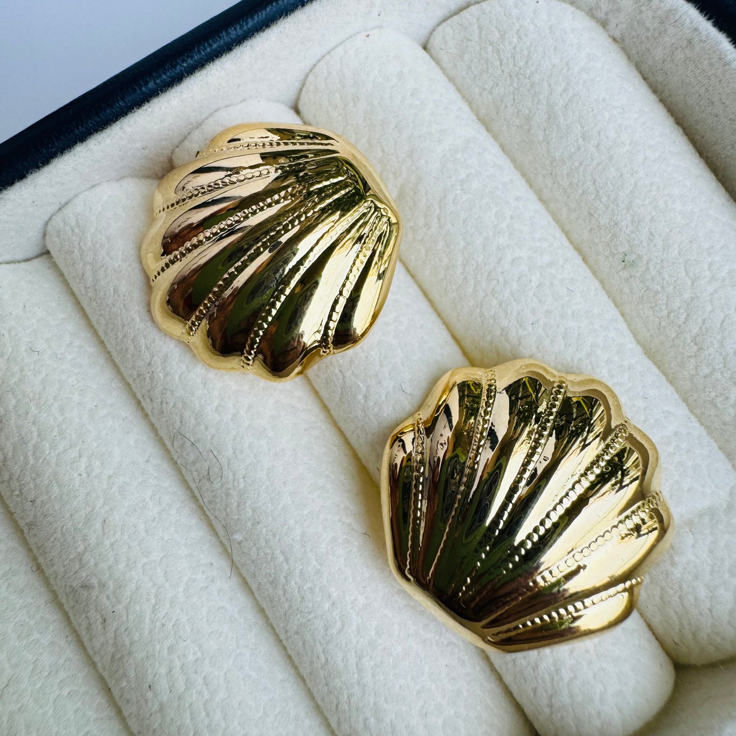Elegant gold shell stud earrings, capturing ocean-inspired beauty, displayed in a luxurious jewelry box with LUSH 24 packaging