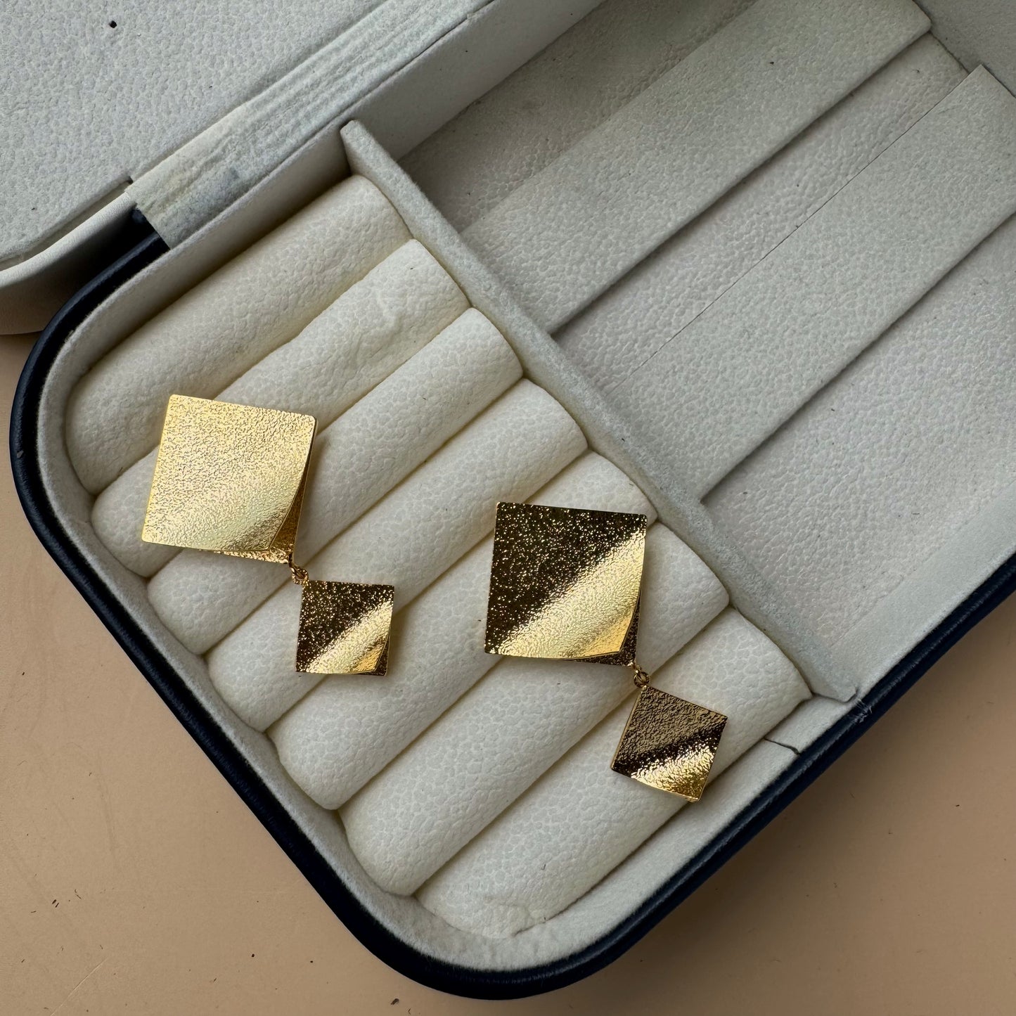 Elegant gold kite earrings in a display box.