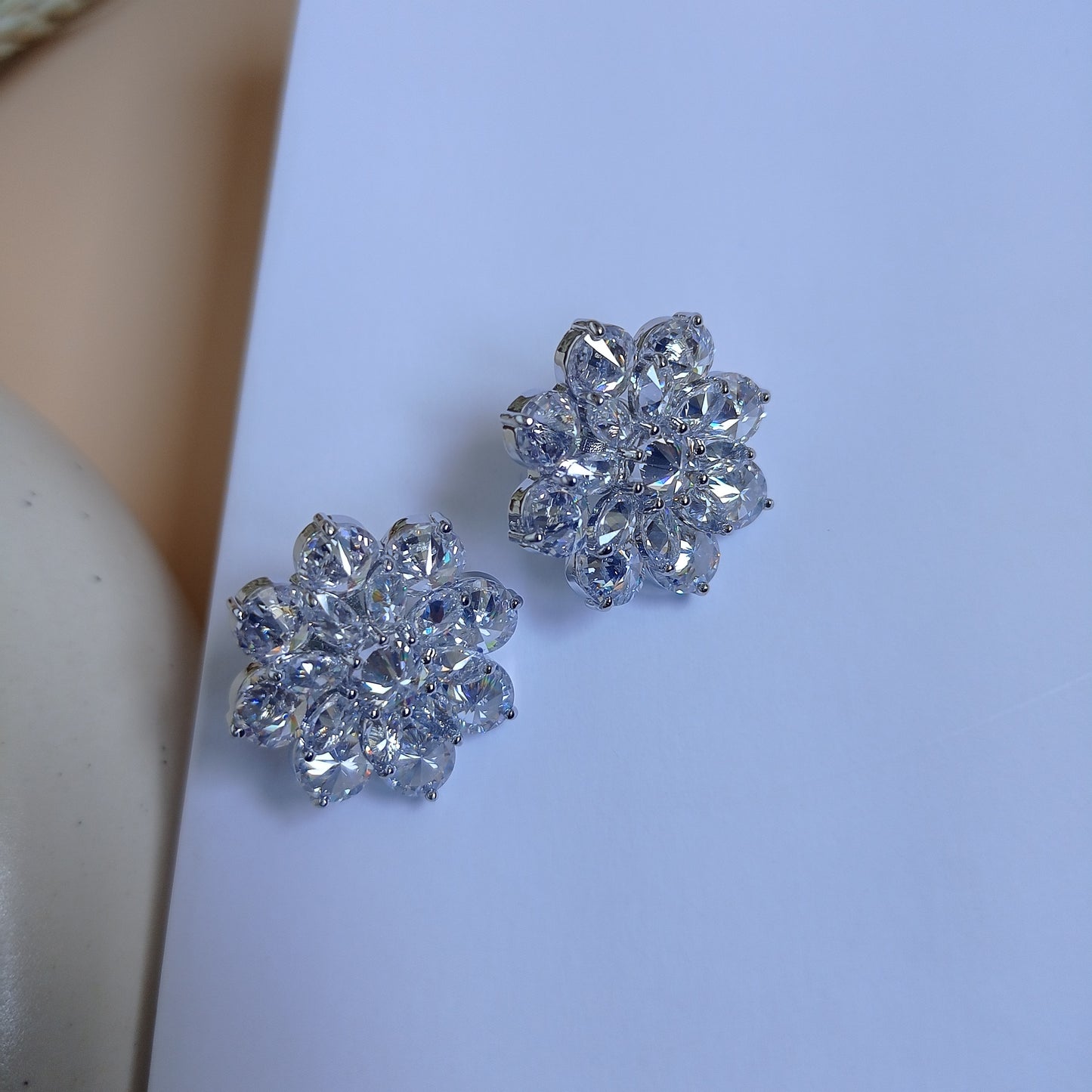 Pair of dazzling silver-tone floral stud earrings featuring an intricate arrangement of marquise-cut and round-cut cubic zirconia stones, creating a sparkling, elegant look. Perfect for adding a touch of glamour to any outfit.