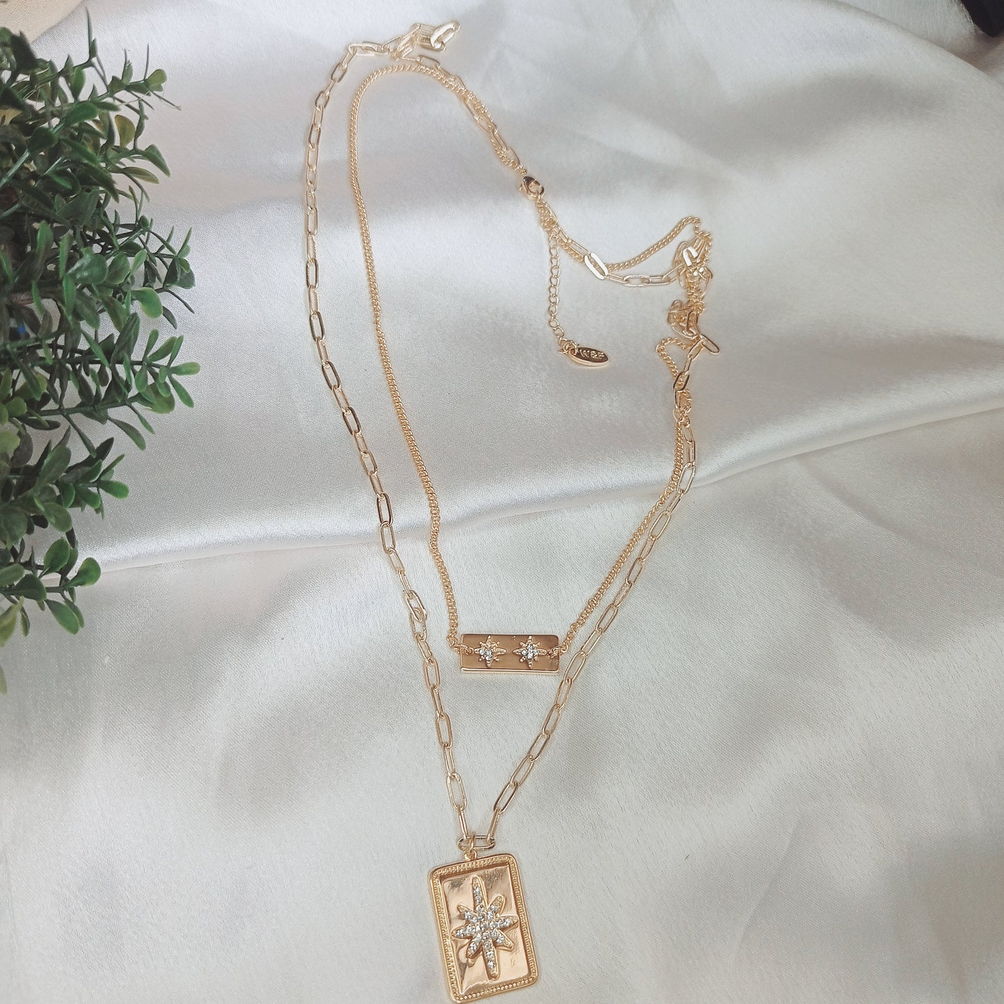 Trendy layered gold necklace with rectangular pendant charms featuring intricate designs, perfect for boho-chic and statement jewelry lovers