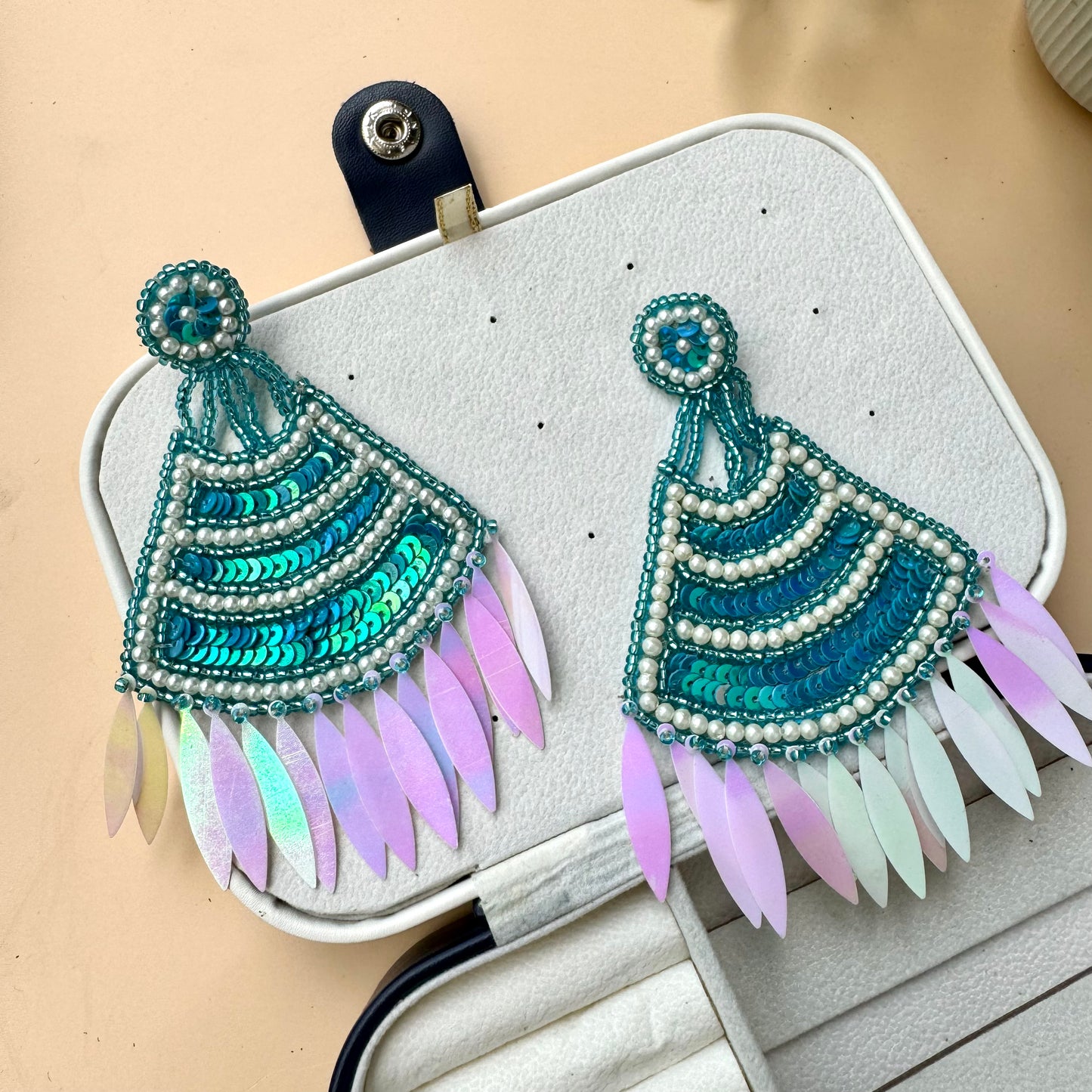 Statement teal sequin and pearl earrings with iridescent feathered drops, exuding a bold and bohemian charm