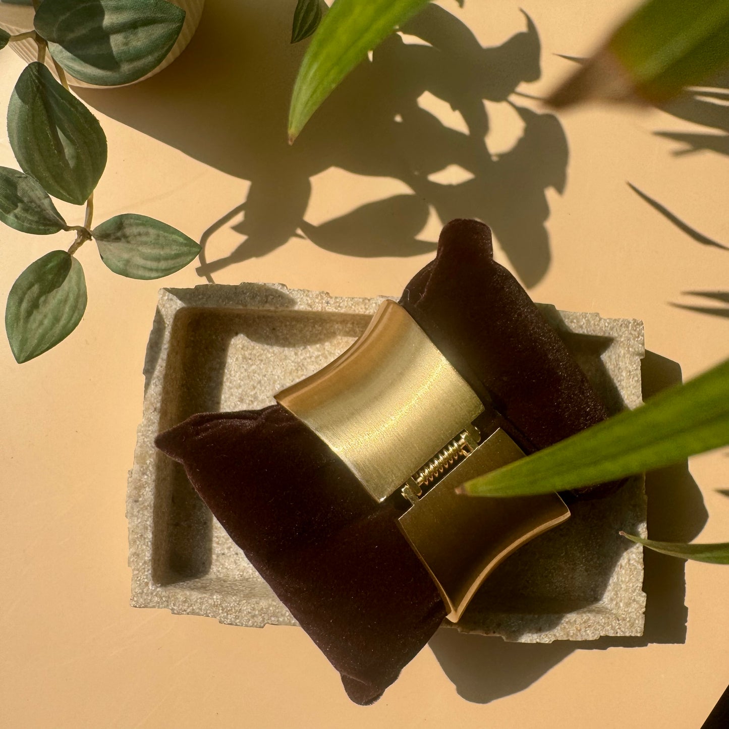 Vintage gold cuff, a classic and symbolic jewelry set. The intertwined design is showcased on a textured light brown surface, suggesting a natural or artisanal presentation