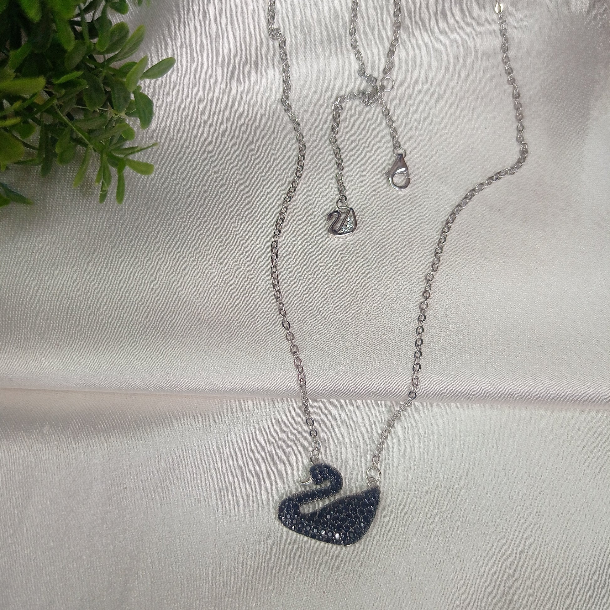 Elegant silver necklace featuring a black swan pendant encrusted with black crystals, adding a touch of sophistication and charm