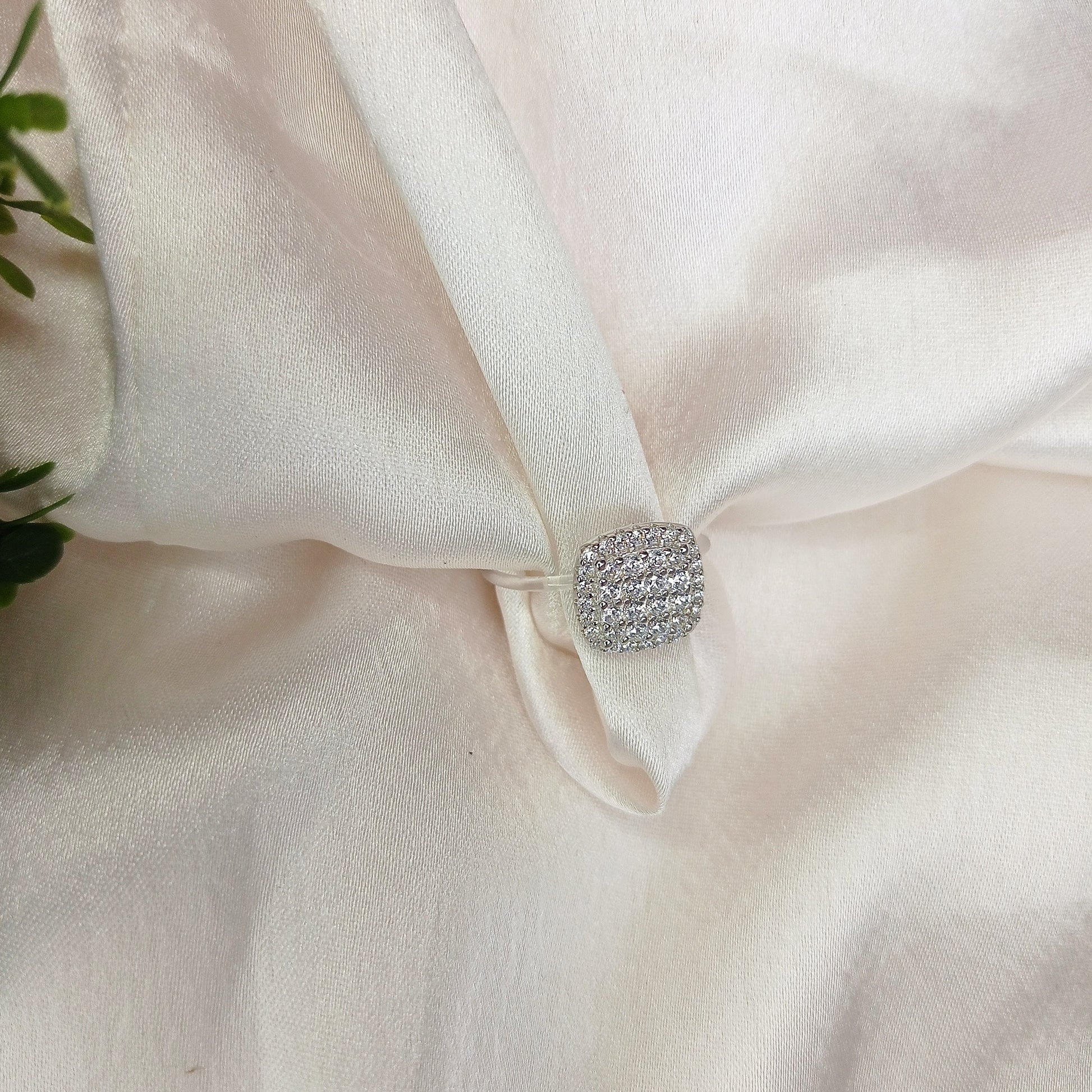 Elegant cushion-cut diamond cluster ring on a woman's hand, featuring a sparkling pave setting and a sleek band—perfect for engagements, weddings, or luxury fashion jewelry lovers