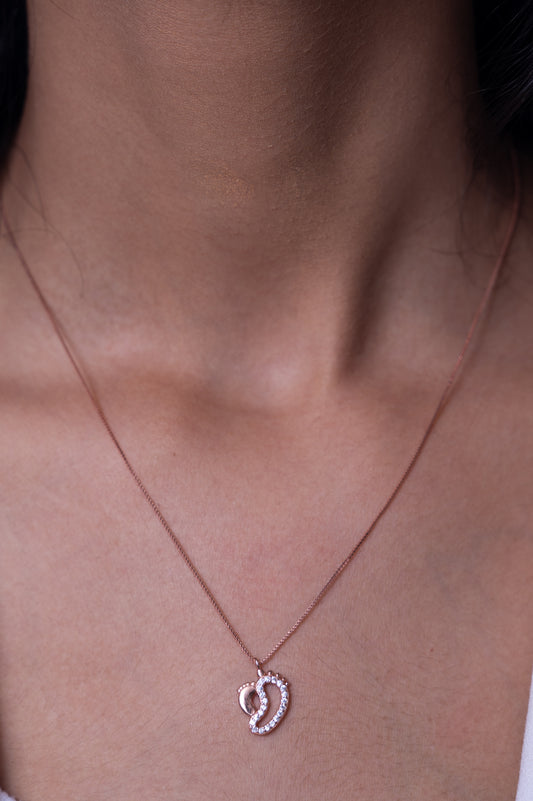 Delicate rose gold necklace with an intertwined heart pendant encrusted with shimmering crystals, symbolizing love and elegance