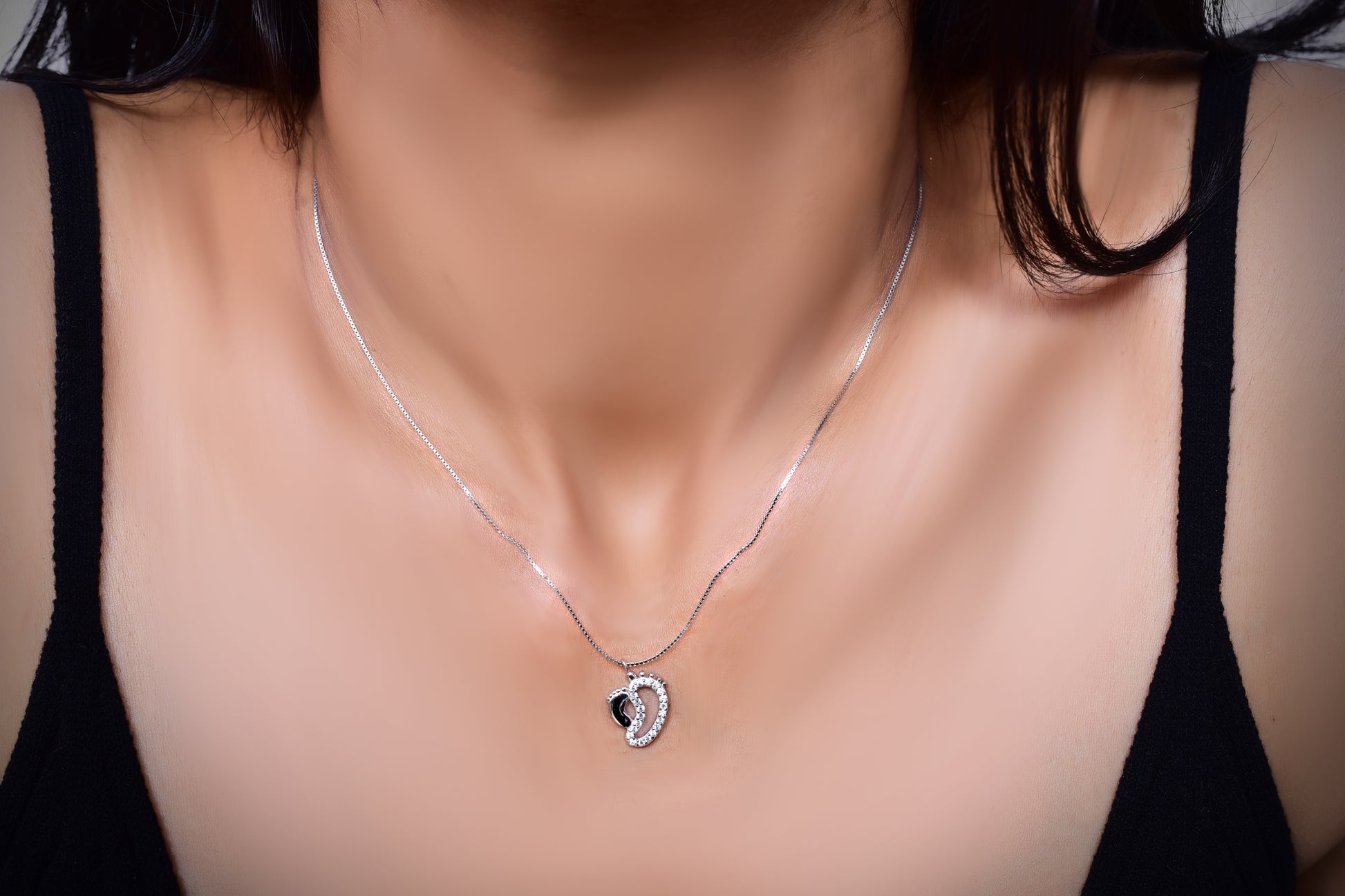 Delicate rose gold necklace with an intertwined heart pendant encrusted with shimmering crystals, symbolizing love and elegance