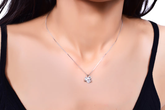 Delicate silver necklace featuring a sparkling floral pendant, elegantly worn with a black outfit. A timeless jewelry piece perfect for everyday wear or special occasions