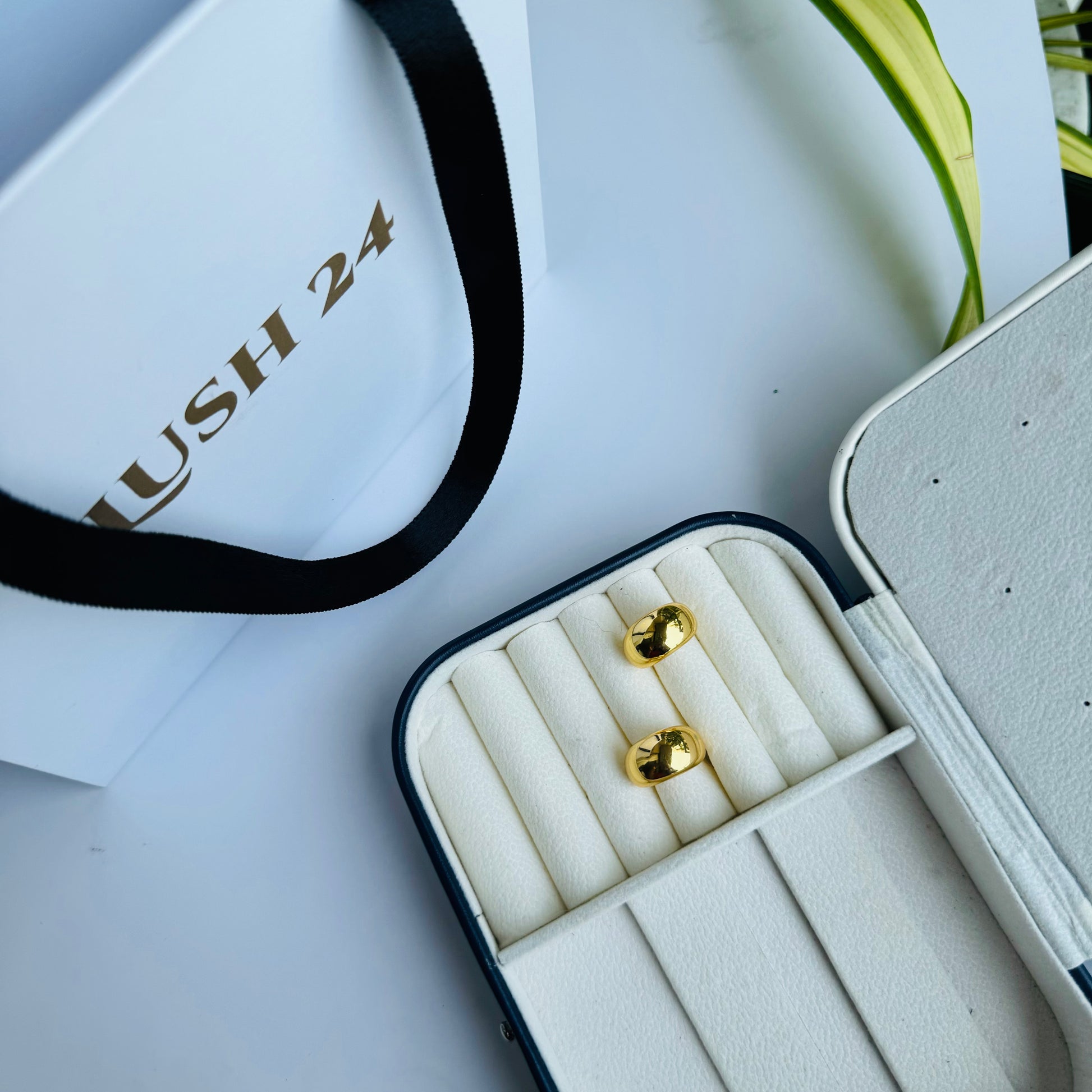 Classic gold stud earrings with a sleek, minimalist design, displayed in an elegant jewelry case for a timeless and sophisticated look