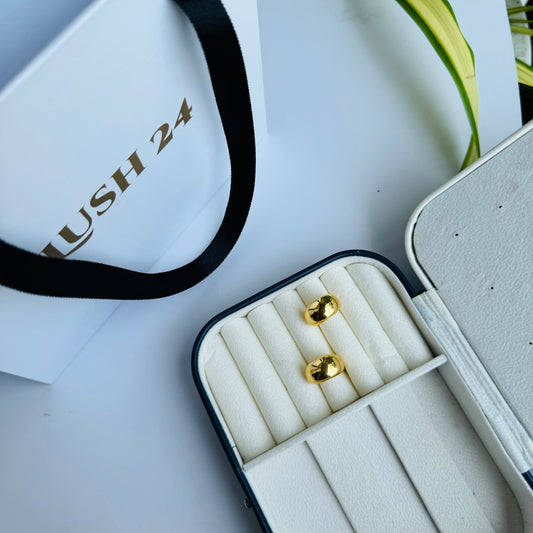 Classic gold stud earrings with a sleek, minimalist design, displayed in an elegant jewelry case for a timeless and sophisticated look