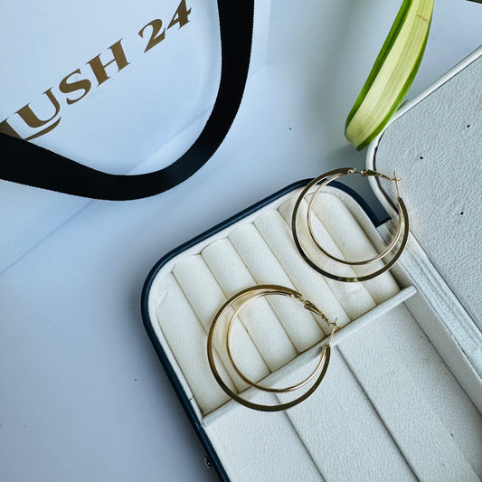 Pair of slender gold hoop earrings in a jewelry case.