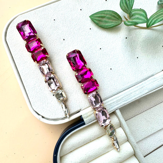 Elegant gradient gemstone drop earrings featuring vibrant pink and blush-toned rectangular crystals, set in gold-tone metal, displayed on a soft jewelry case