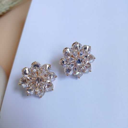 Pair of gold-tone floral stud earrings adorned with sparkling marquise-cut and round-cut cubic zirconia stones, creating a luxurious and elegant look. Perfect for special occasions or adding a touch of glamour to any outfit.