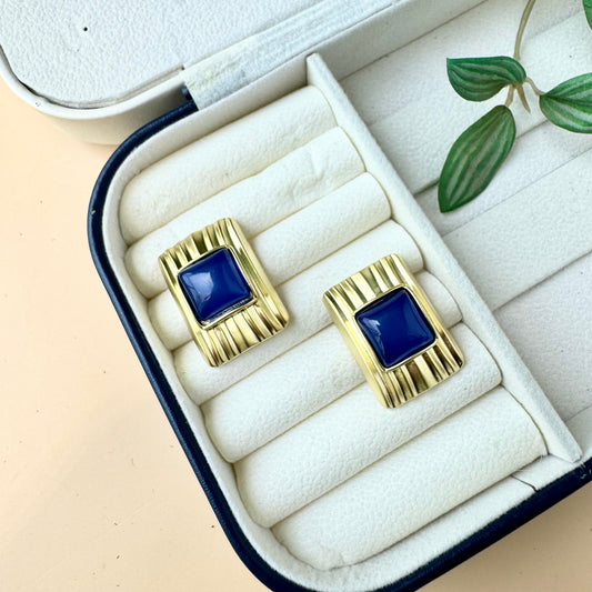 Stylish gold and blue statement earrings in a jewelry organizer