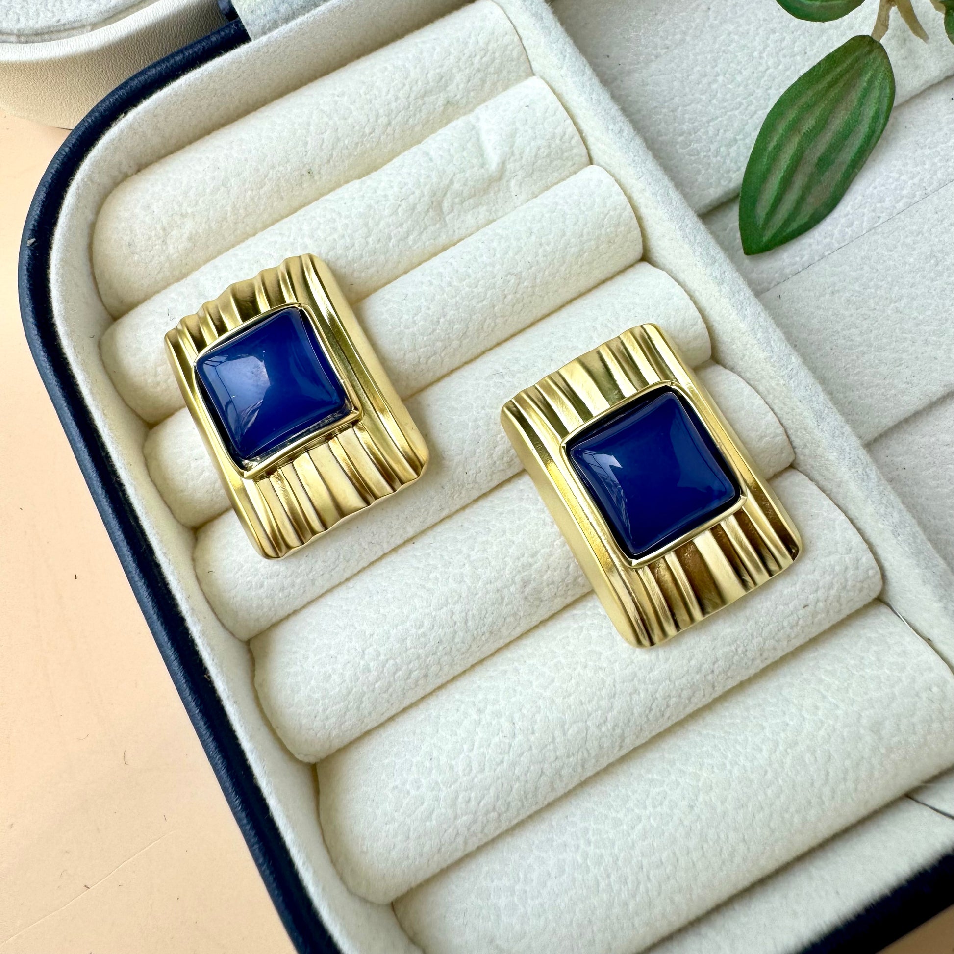 Stylish gold and blue statement earrings in a jewelry organizer