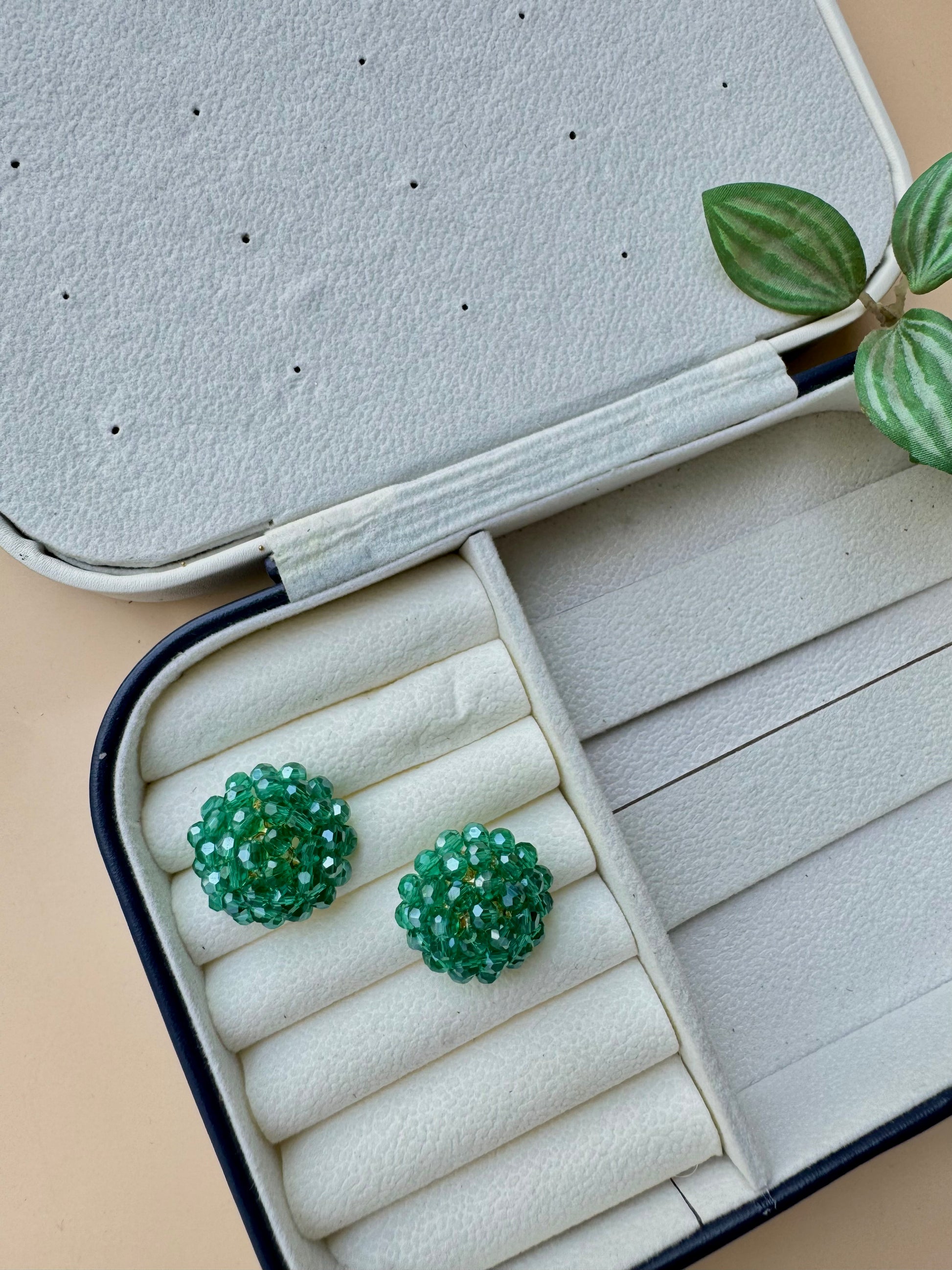 Green iridescent berry bead earrings in a case