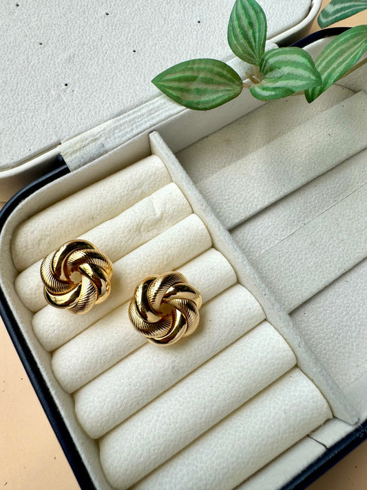 Tarnish-free gold studs on a pillow