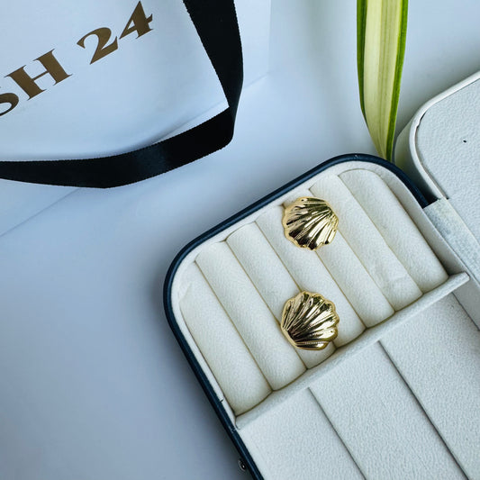 Elegant gold shell stud earrings, capturing ocean-inspired beauty, displayed in a luxurious jewelry box with LUSH 24 packaging