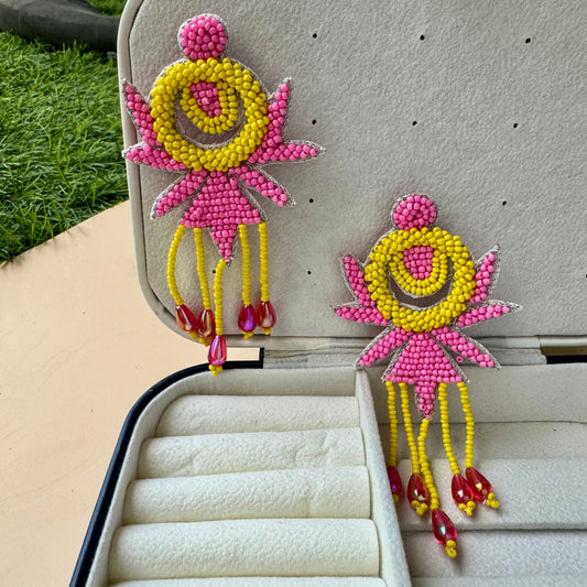 Vibrant pink and yellow beaded statement earrings with playful fringe and red teardrop accents, radiating bold, eclectic energy