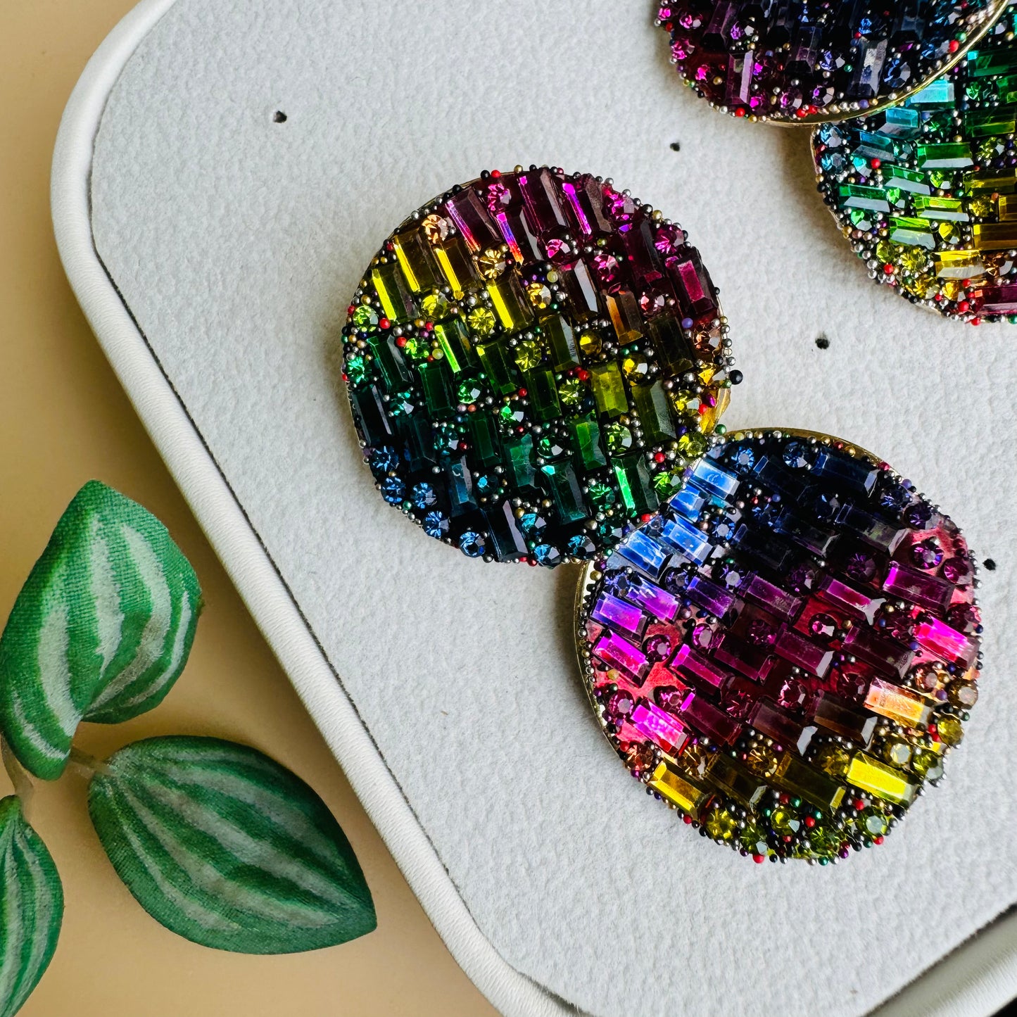 Shimmering earrings featuring a mosaic of rainbow crystals