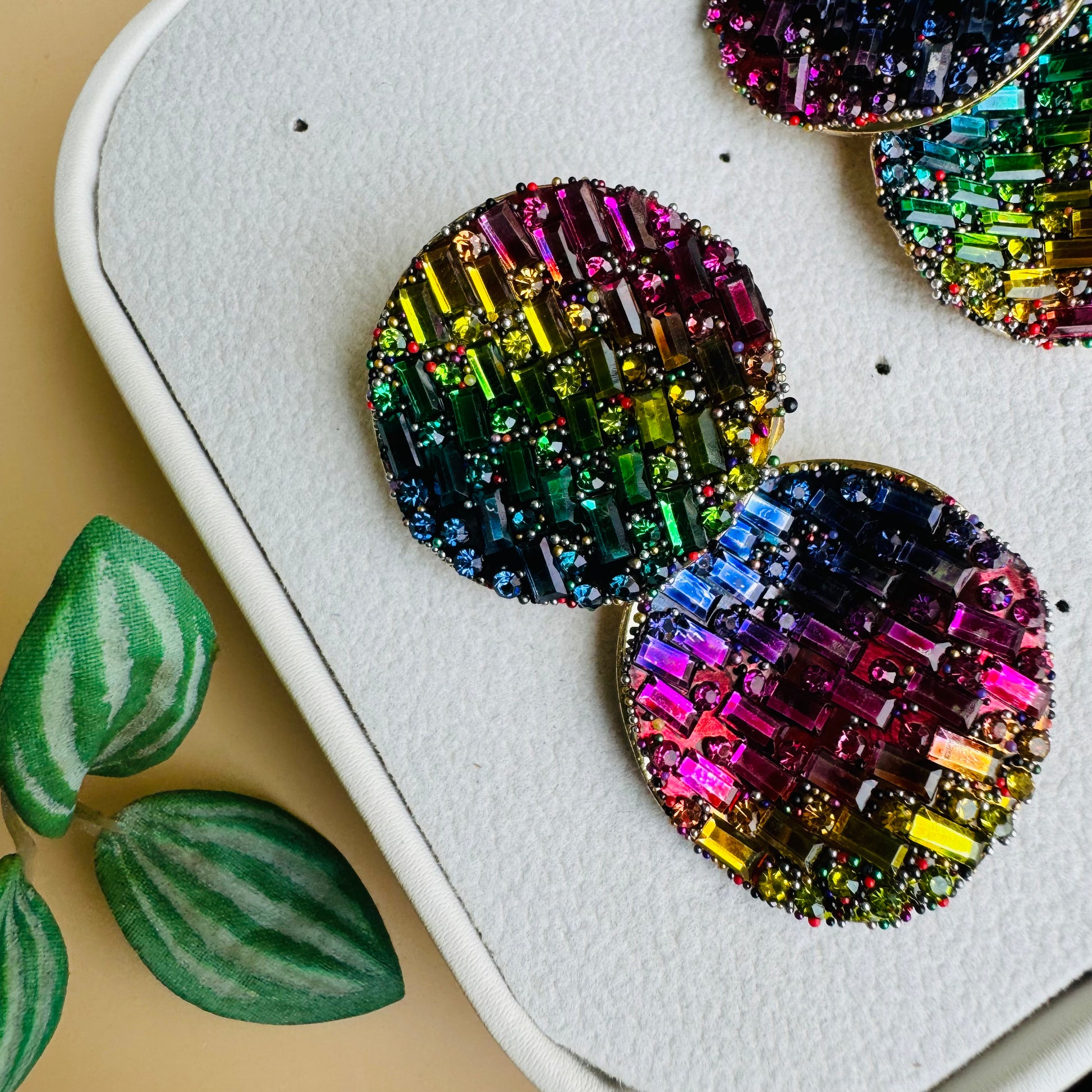 Shimmering earrings featuring a mosaic of rainbow crystals