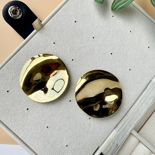 An 18k gold-plated stainless steel mirror finish earrings showcased on a brown velvet pillow. The earring has a solid, tarnish-free appearance.