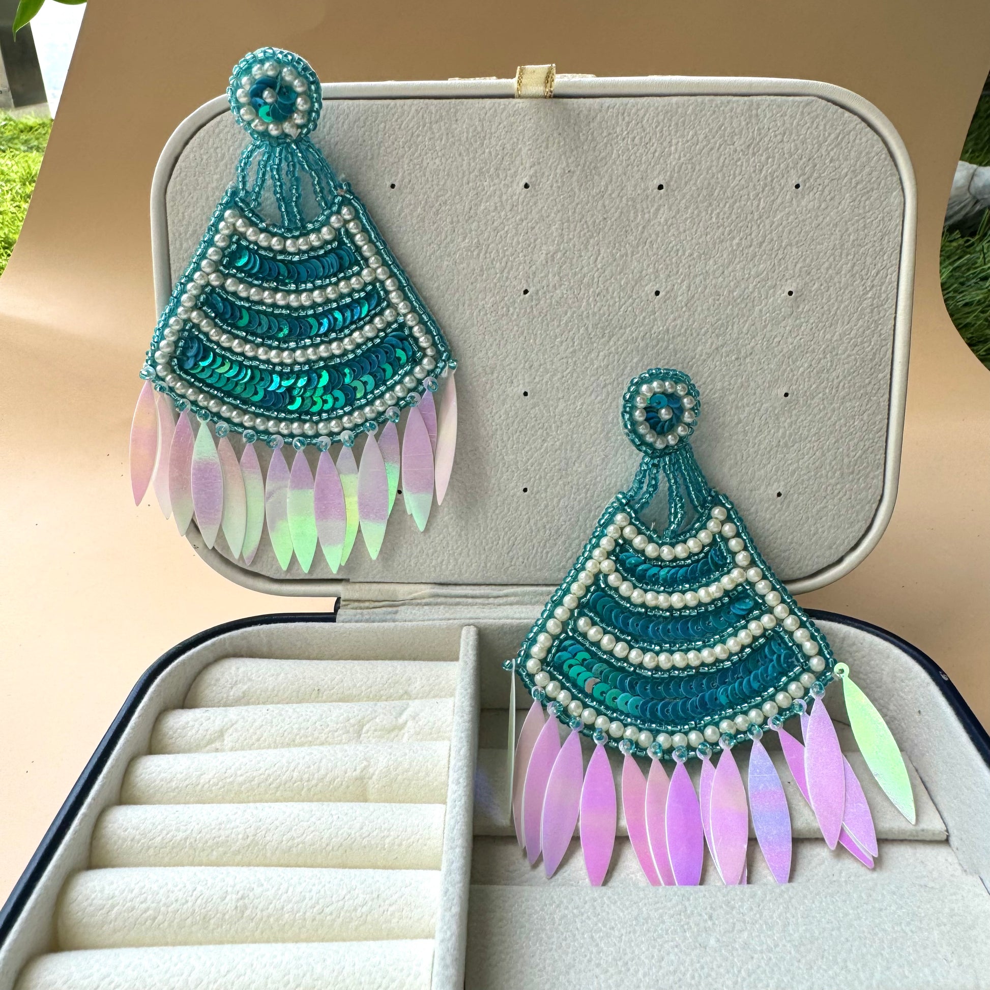 Statement teal sequin and pearl earrings with iridescent feathered drops, exuding a bold and bohemian charm